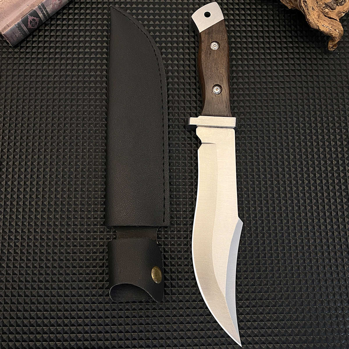 Stainless steel hunting knife with a wooden handle, paired with a black leather sheath, an essential tool for adventurers