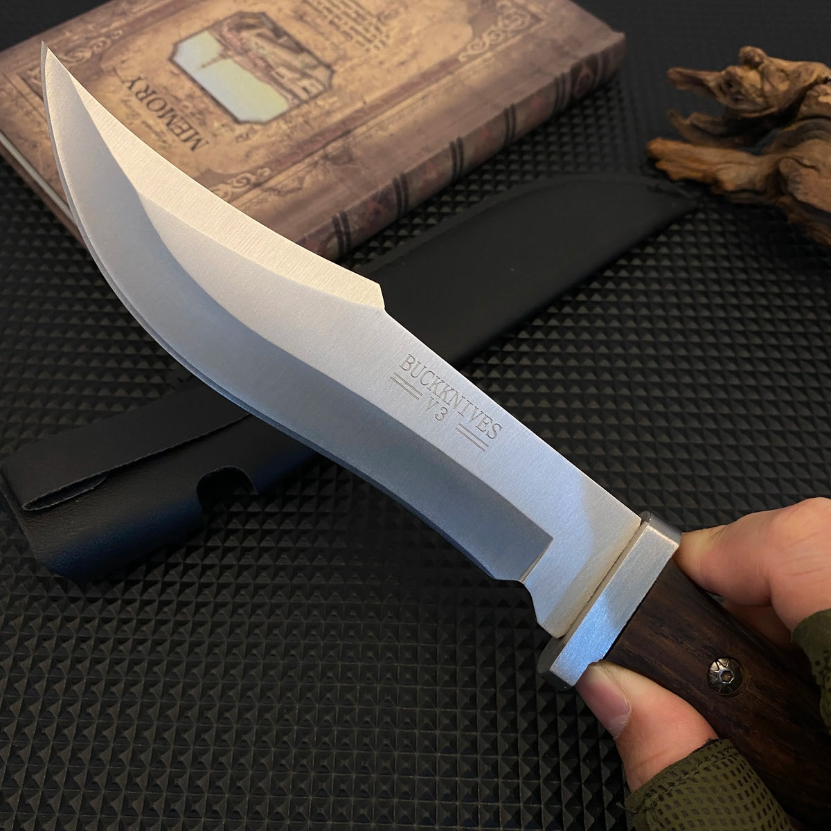 Stainless steel hunting knife with a wooden handle, paired with a black leather sheath, an essential tool for adventurers